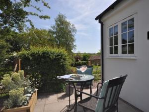 a patio with a table and chairs in a garden at 1 Bed in Upper Brailes 57103 in Upper Brailes