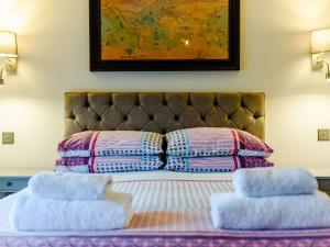 1 cama con 2 almohadas y un mapa en la pared en 2 Bed in Bakewell 91038, en Bakewell