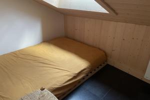 a small bed in a small room with a window at Lovely family nest in Courchevel in Courchevel