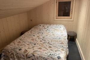 a bed in a room with a comforter on it at Lovely family nest in Courchevel in Courchevel