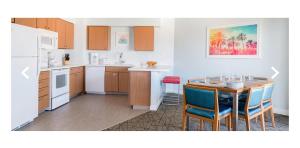 a kitchen with a table and chairs and a kitchen with white appliances at Worldmark in Anaheim
