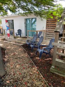 un grupo de sillas y una mesa frente a una casa en Las Olas studios, en Arecibo