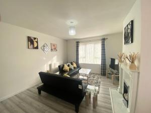a living room with a couch and a fireplace at Comfy & Affordable home - Sleeps 7, free off-street parking near City centre, Cadbury World & Cannon Hill Park in Kings Norton