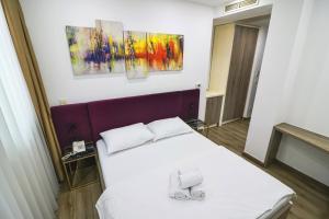 a bedroom with a bed with two shoes on it at Hotel National in Zagreb