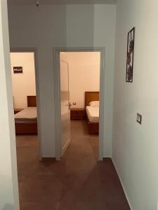 un pasillo con 2 camas y una puerta a un dormitorio en Dar Maya, en Salakta