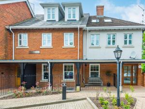 a brick house with a gate and a street light at 1 Bed in Brockenhurst 87525 in Brockenhurst