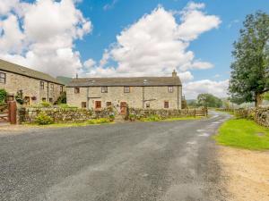 an empty road in front of a stone house at 2 bed in Ramsgill 89166 in Bouthwaite