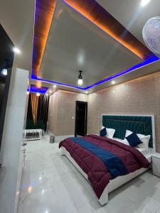 a bedroom with a large bed with blue lights at As Hotel Expo Inn in Greater Noida