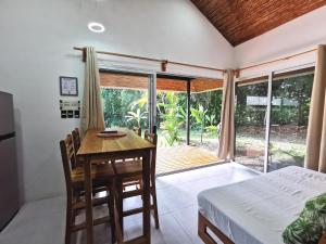 a bedroom with a desk and a bed and a balcony at Armadillo Eco Bungalows - Santa Teresa in Santa Teresa Beach