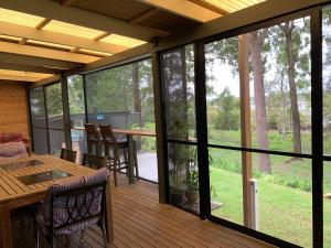 a screened in porch with a table and chairs at Pet Friendly Waterfront Holiday House on Peaceful Island with Bikes and Kayaks 