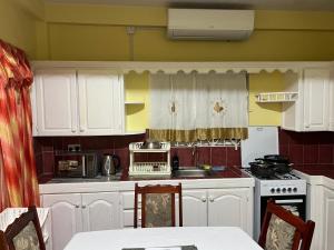 a kitchen with white cabinets and a stove at Estuary Apartment 2 in Dunfermline