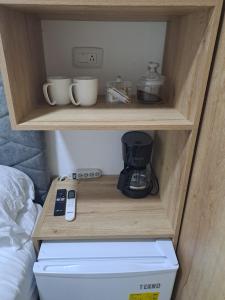 einen Schrank mit Kaffeemaschine und Kaffeemaschine in der Unterkunft Ultra mini suite privada con baño in Guayaquil