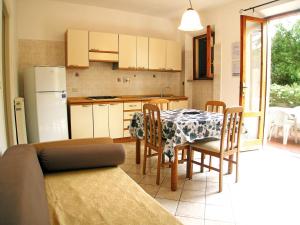 - une cuisine et une salle à manger avec une table et des chaises dans l'établissement L' Oleandro, à Marina di Campo