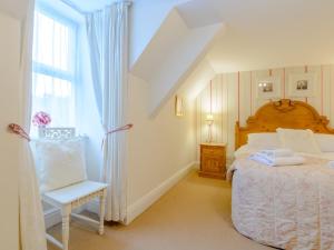 a bedroom with a bed and a chair and a window at 2 Bed in Rothbury 74811 in Rothbury