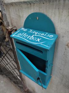 niebieska skrzynka pocztowa jest przymocowana do ściany w obiekcie The Turquoise Letterbox - Twin at Central w mieście Kolkata