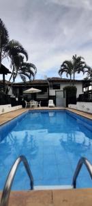 una grande piscina con palme sullo sfondo di Geribá - A casa mais Buziana e charmosa de Búzios a Búzios