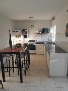 een keuken met een tafel en stoelen en een koelkast bij Departamento en Mendoza in La Cieneguita