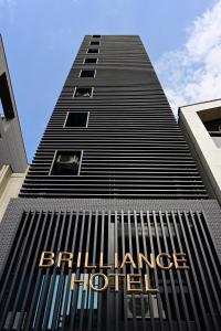 名古屋的住宿－BRILLIANCE Hotel，一座高大的黑色建筑,上面有标志