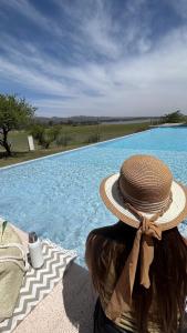una mujer con un sombrero de paja sentada junto a una piscina en Inigualable vista en Los Molinos in 