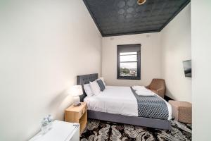 Schlafzimmer mit einem Bett, einem Fenster und einem Waschbecken in der Unterkunft Romano's Hotel & Suites Wagga Wagga in Wagga Wagga