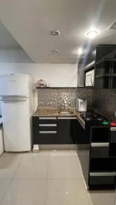 uma cozinha com um frigorífico branco e um lavatório em Studio Living Lê Premier Jardins em São Paulo
