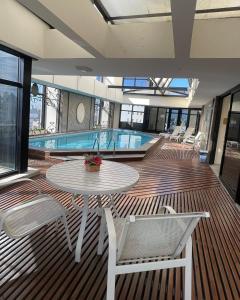 um deque com uma mesa e cadeiras e uma piscina em Studio Living Lê Premier Jardins em São Paulo