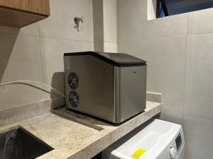 a microwave sitting on a counter in a bathroom at Cobertura Milagres do Chef in São Miguel dos Milagres
