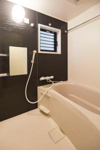 uma casa de banho com uma banheira e uma janela em MONTANA FLAT YEBISU - Vacation STAY 9873 em Osaka