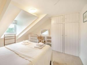 a white bedroom with a bed and a desk at 2 Bed in Fowey 73074 in Fowey