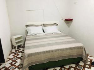 Posto letto in una piccola camera con parete bianca. di Casarão de aluguel a Pacoti