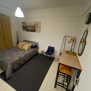 een slaapkamer met een bed, een bureau en een stoel bij Cardia’s Guest House in Sacavém
