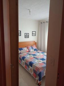 a bedroom with a bed with a quilt on it at Apartamento locação diária - residencial Belize in Botucatu