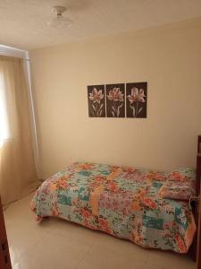 a bedroom with a bed and two pictures on the wall at Apartamento locação diária - residencial Belize in Botucatu