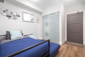 Un dormitorio con una cama azul y una puerta en 3 Beds w/ CN Tower View Right Beside Rogers Centre! en Toronto