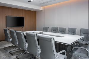 a conference room with a white table and chairs at UrCove by Hyatt Foshan Downtown in Foshan