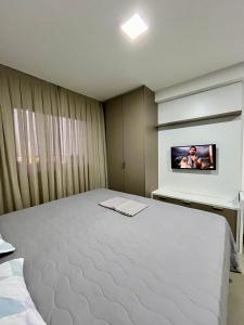 een slaapkamer met een bed en een tv aan de muur bij Studio cama King Size Westfit. in Mossoró