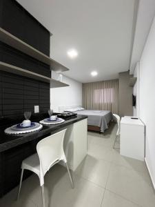 een kamer met een bed en een keuken met stoelen bij Studio cama King Size Westfit. in Mossoró