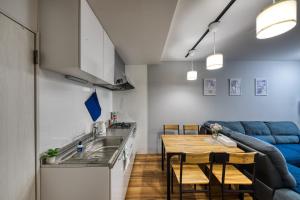 cocina y sala de estar con mesa y sofá en Osaka vacation rental 菫Sumire en Osaka