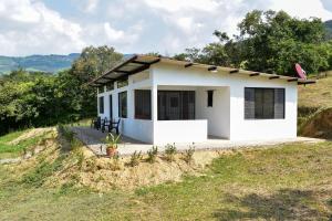 una pequeña casa blanca en la cima de una colina en Piedras del Sol Casa Campestre, en Guaduas
