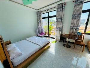 潘切的住宿－Lộc Vừng Homestay，一间卧室配有一张床、一张书桌和一个窗户。