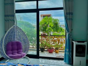 une chaise suspendue en face d'une fenêtre dans l'établissement Lộc Vừng Homestay, à Phan Thiết