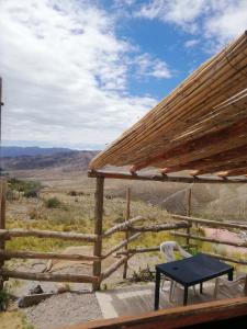 - une table et une chaise sur une terrasse couverte avec vue dans l'établissement Vidatierra, à Potrerillos