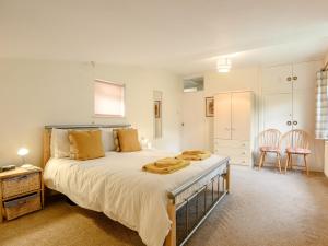 a bedroom with a large bed with yellow pillows at 2 Bed in Coleford 60103 in Coleford