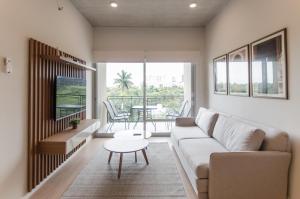 uma sala de estar com um sofá e uma mesa em Modern 2 Bedroom Apartment Near Paseo La Galeria em Assunção