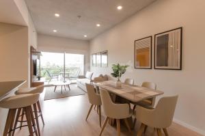 uma sala de jantar e sala de estar com mesa e cadeiras em Modern 2 Bedroom Apartment Near Paseo La Galeria em Assunção