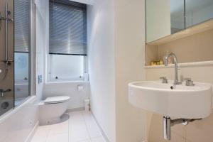 bagno bianco con lavandino e servizi igienici di London Bridge Beauty Luxury 2bed 2bath a Londra