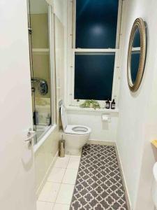 a bathroom with a toilet and a window at London Bridge Beauty Luxury 2bed 2bath in London