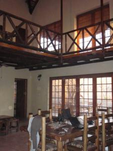 Habitación con mesa de madera y algunas ventanas. en Les 3 Marulas, en Marloth Park