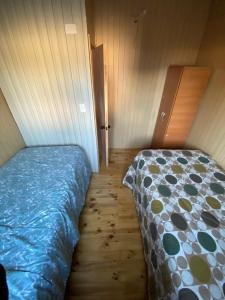 1 dormitorio con 1 cama y suelo de madera en Cabañas-La vara senda sur, en La Chamiza