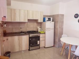 a small kitchen with a stove and a refrigerator at ALTOS DE ALEM in Alta Gracia